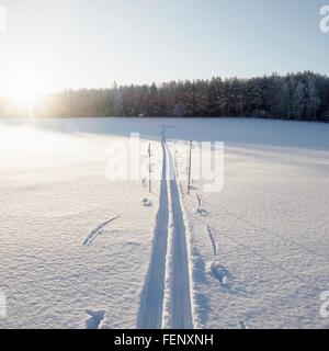 Coperte di neve paesaggio soleggiato con le piste di sci e bastoncini da sci, Ural, Russia Foto Stock