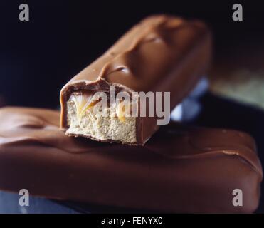 Due latte impilati barrette di cioccolato con caramello e riempimento di torrone Foto Stock