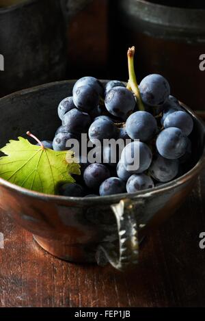 Elevato angolo di visione del grappolo di uva nera nel vintage tazzina Foto Stock