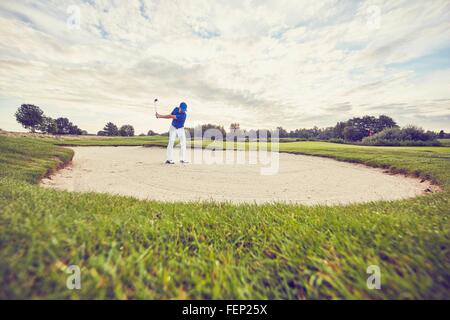 Il Golfer colpendo la sfera nella trappola di sabbia, Korschenbroich, Dusseldorf, Germania Foto Stock