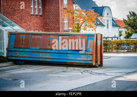 Grande contenitore blu con ruggine sulla strada Foto Stock