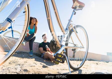 Matura per rilassarsi dopo le passeggiate in mountain bike, biciclette accanto a loro. Foto Stock