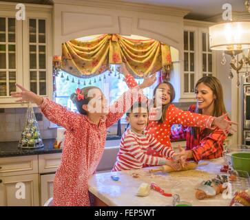 Madre e bambini ingannare intorno in cucina Foto Stock