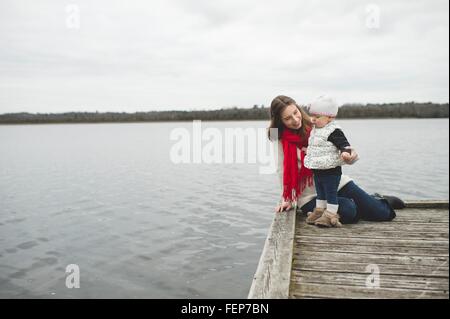 Madre e figlia sul molo, figlia guardando l'acqua Foto Stock