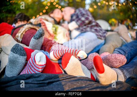 Intrecciano famiglia piedi socked giacente sulla coperta di boschi Foto Stock