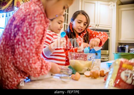 Bambini in cucina indossando pigiami cottura Foto Stock