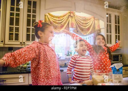 Bambini in cucina indossando pigiami bracci aperti guardando lontano sorridente Foto Stock