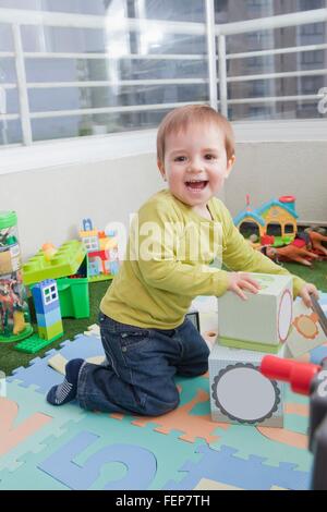 Baby boy impilamento blocchi giocando a casa Foto Stock