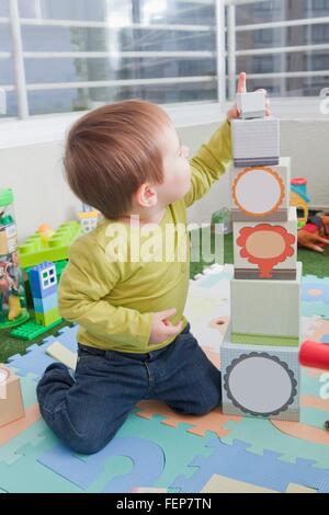 Baby boy impilamento blocchi giocando a casa Foto Stock