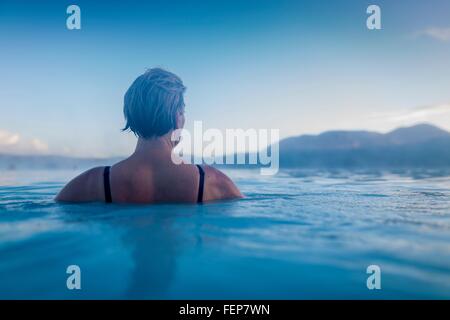 Backview della donna nelle acque della laguna Foto Stock