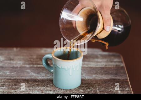 L'uomo versando il caffè dal filtro caffettiera Foto Stock