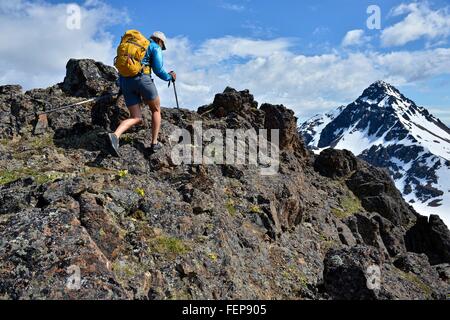 Femmina scalatore di montagna salita, vista posteriore, Chugach State Park, Anchorage, Alaska, STATI UNITI D'AMERICA Foto Stock