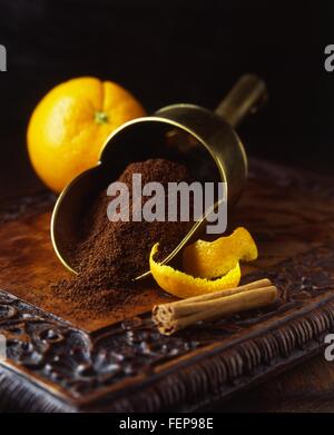 Arance fresche e bucce con la stecca di cannella e caffè appena macinato in scoop vintage Foto Stock