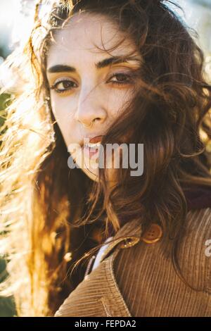 Ritratto di giovane donna con capelli ondulati, close-up Foto Stock