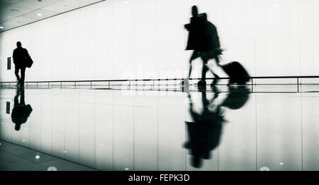I passeggeri con bagaglio a mano aeroporto di avvicinamento alle porte di protezione. Foto Stock