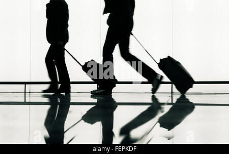 I passeggeri con bagaglio a mano aeroporto di avvicinamento alle porte di protezione. Foto Stock