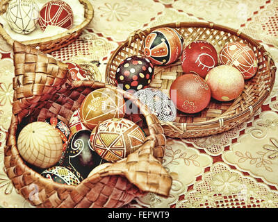 Multicolore di uova di pasqua in vasi di paglia su una tabella.tonica immagine. Foto Stock