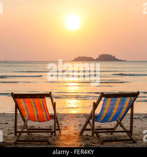 Coppia di poltrone a sdraio sulla spiaggia del mare. Foto Stock