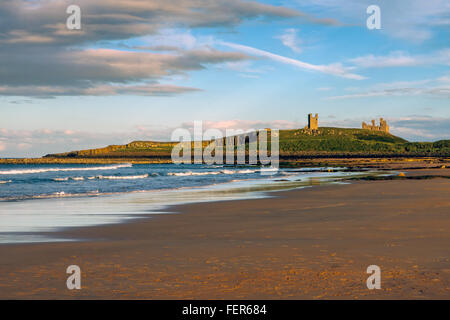 Tramonto sul castello di Dunstanburgh Foto Stock