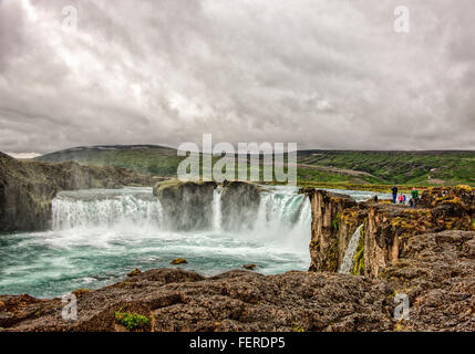 1 agosto, 2015 - BÀ¡RÃ°Ardalur distretto, Nord-Centro Islanda Islanda - i turisti visualizza la forma a ferro di cavallo a doppia cascata del famoso GoÃ°afoss da un promontorio roccioso sulla sua west bank. Uno dei più spettacolari e belle cascate in Islanda, sul fiume SkjÃ¡lfandafljÃ³t, il suo nome cascata degli Dèi è dalla leggenda di quindi Lawspeaker Porgeir gettando il suo dio norvegese statue in cade in un atto simbolico della conversione di Islanda al Cristianesimo nell'anno 1000. Il turismo è diventato un settore in crescita dell'economia e l'Islanda è diventata una destinazione turistica preferita. (Credito Foto Stock