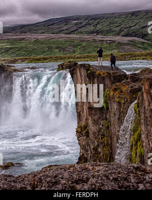 1 agosto, 2015 - BÀ¡RÃ°Ardalur distretto, Nord-Centro Islanda Islanda - i turisti visualizza la forma a ferro di cavallo a doppia cascata del famoso GoÃ°afoss da un promontorio roccioso sulla sua west bank. Uno dei più spettacolari e belle cascate in Islanda, sul fiume SkjÃ¡lfandafljÃ³t, il suo nome cascata degli Dèi è dalla leggenda di quindi Lawspeaker Porgeir gettando il suo dio norvegese statue in cade in un atto simbolico della conversione di Islanda al Cristianesimo nell'anno 1000. Il turismo è diventato un settore in crescita dell'economia e l'Islanda è diventata una destinazione turistica preferita. (Credito Foto Stock