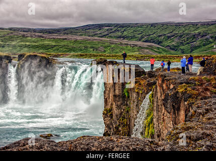 1 agosto, 2015 - BÀ¡RÃ°Ardalur distretto, Nord-Centro Islanda Islanda - i turisti visualizza la forma a ferro di cavallo a doppia cascata del famoso GoÃ°afoss da un promontorio roccioso sulla sua west bank. Uno dei più spettacolari e belle cascate in Islanda, sul fiume SkjÃ¡lfandafljÃ³t, il suo nome cascata degli Dèi è dalla leggenda di quindi Lawspeaker Porgeir gettando il suo dio norvegese statue in cade in un atto simbolico della conversione di Islanda al Cristianesimo nell'anno 1000. Il turismo è diventato un settore in crescita dell'economia e l'Islanda è diventata una destinazione turistica preferita. (Credito Foto Stock