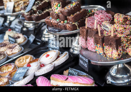 Una varietà di torte e brownie al cioccolato sul display in un negozio. Foto Stock