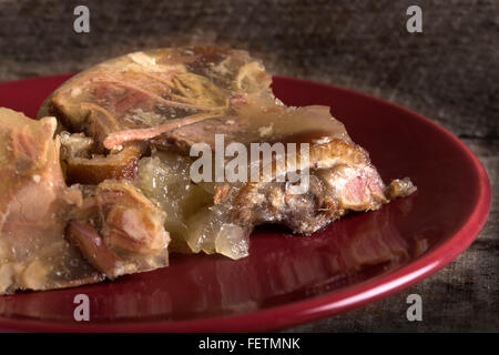 Close up di maiale in gelatina aspic - sulla targhetta rossa Foto Stock