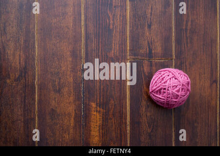 Matassa rosa su legno marrone striato tabella Foto Stock