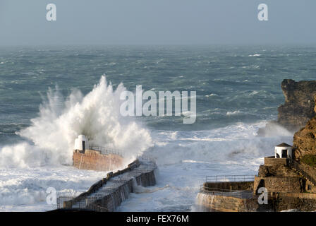 Di grandi onde che si infrangono sulla Portreath pier in Cornovaglia, Inghilterra, durante la tempesta Imogen. Foto Stock