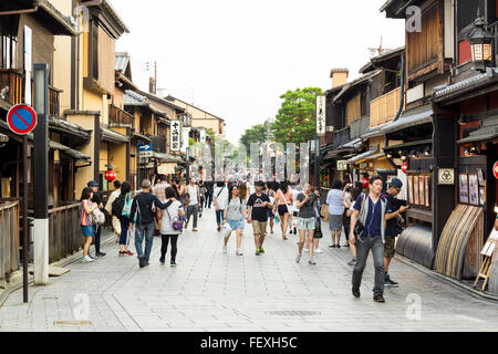 I turisti a piedi verso il basso Hanami-Koji dori, la strada nel cuore di Gion e la sua famosa Geisha entertainment district foderato con Foto Stock