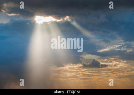 Sun Ray luce attraverso giù dalla pioggia durante il tramonto Foto Stock