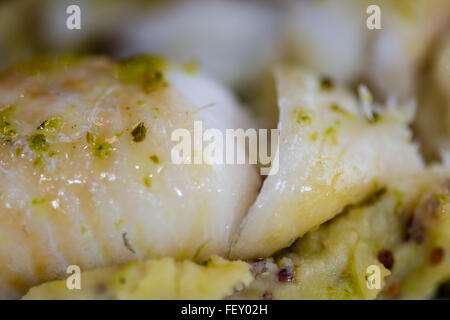 Eglefino con grano intero mash e aglio prezzemolo burro. Il ristorante francese preparata piatto di pesce con purea di patate Foto Stock