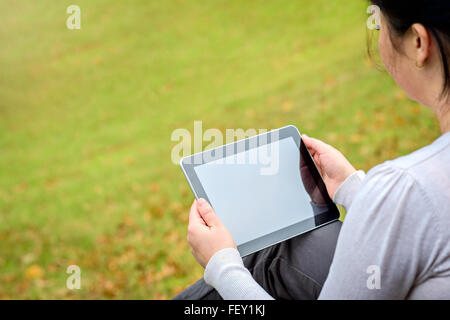 Donna al lavoro su un tablet PC in autunno park Foto Stock