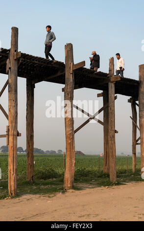 Persone attraversano U Bein Bridge - la più lunga passerella in legno di teak nel mondo, Amarapura vicino a Mandalay, Birmania (Myanmar) Foto Stock