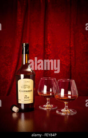 Una bottiglia di Calvados Calvados In Normandia, Francia, con due bicchieri Foto Stock