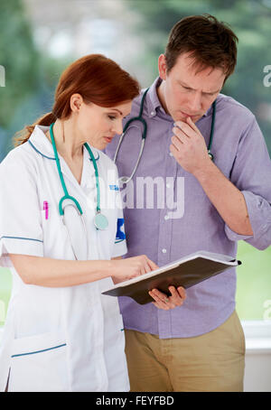 Medico e infermiere discutendo le note Foto Stock
