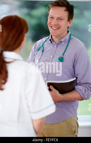 Medico e infermiere discutendo le note Foto Stock