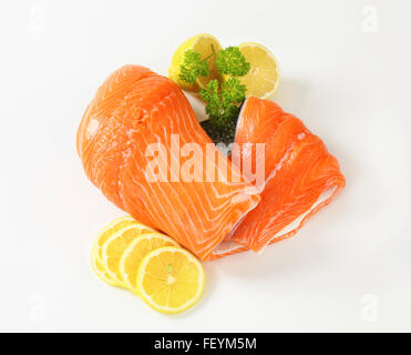 Materie filetto di salmone e le fette di limone su sfondo bianco Foto Stock