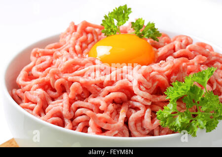 In prossimità delle materie di carne macinata con tuorlo d'uovo nella ciotola bianco Foto Stock