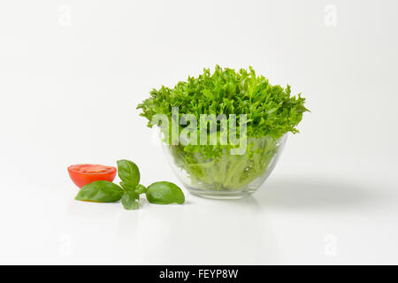 Ciotola di fresche foglie di lattuga su sfondo bianco Foto Stock