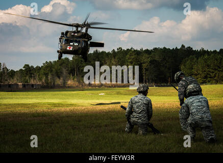 Stati Uniti Air Force aviatori da 321contingenza squadrone di risposta dal giunto di baseGuire-Dix Mc-Lago Hurst, N.J., attende per un esercito Mississippi Guardia Nazionale evacuazione medica UH-60 Black Hawk elicottero di avvicinarsi a Camp Shelby forze congiunte Training Center, Miss., durante l'esercizio di distribuzione Turbo, Ottobre 29, 2015. Gli Stati Uniti Il trasporto del comando test di esercizio la Joint Task Force Port-Opening è in grado di offrire e distribuire il carico durante l'assistenza umanitaria. Foto Stock