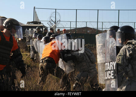 Esercito Polacco soldati assegnati alla multinazionale battaglia Group-East inoltra il comando Post svolgono il ruolo dei manifestanti violenti durante un nov. 5, 2015, folla e antisommossa esercizio presso il Camp Nothing Hill vicino a Leposavic, in Kosovo. L'esercizio congiunto ha permesso la FCP NEGLI STATI UNITI Esercito e Germania società di manovra per provare la loro risposta combinata ad una folla violenta e ripristinare la sicurezza e la sicurezza. Il protocollo FCP è parte della NATO in Kosovo dell forza di pace missione di supporto. Foto Stock