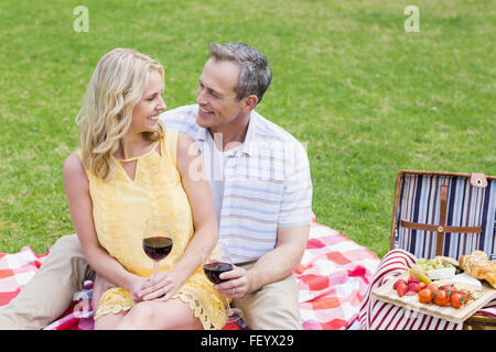 Felice coppia avente un picnic con il vino Foto Stock