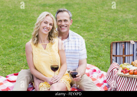 Felice coppia avente un picnic con il vino Foto Stock