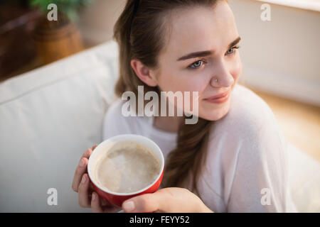 Pretty Woman rilassante sul lettino con caffè Foto Stock