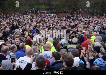 Ashbourne, Derbyshire, Regno Unito. Il 9 febbraio, 2016. Il dipinto a mano la sfera viene effettuata attraverso il folle prima di teh inizio della Shrovetide football. Gli obiettivi sono tre miglia di distanza e il gioco si svolge in due ore di otto periodi Martedì Grasso e il Mercoledì delle Ceneri. Credito: Nigel Spooner/Alamy Live News Foto Stock