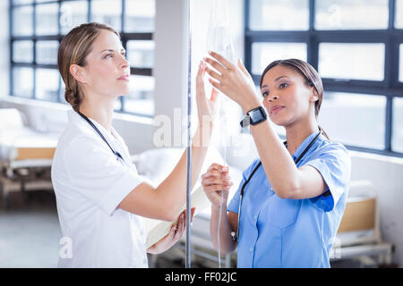 Il team medico di preparare una flebo IV Foto Stock