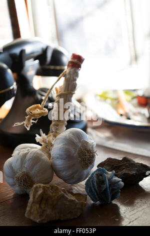 Stringa di aglio fotografati con luce naturale su un comò in legno Foto Stock