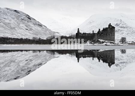 Nuvole basse telaio sopra Loch Awe e le rovine di Kilchurn Castle su un tetro inverno mattina Foto Stock